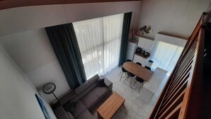 A modern living area with a sofa, coffee table, and dining table. - Residence with a pool next to the Moliets Golf Course; Duplex apartment for 8–9 people, 10 minutes from the ocean (Moliets-et-Maa)