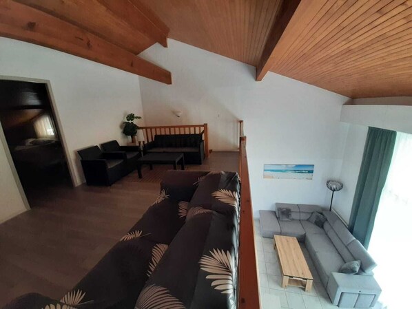 A modern living room with a sofa, a coffee table, and a grey sectional sofa. - Residence with a pool next to the Moliets Golf Course; Duplex apartment for 8–9 people, 10 minutes from the ocean (Moliets-et-Maa)