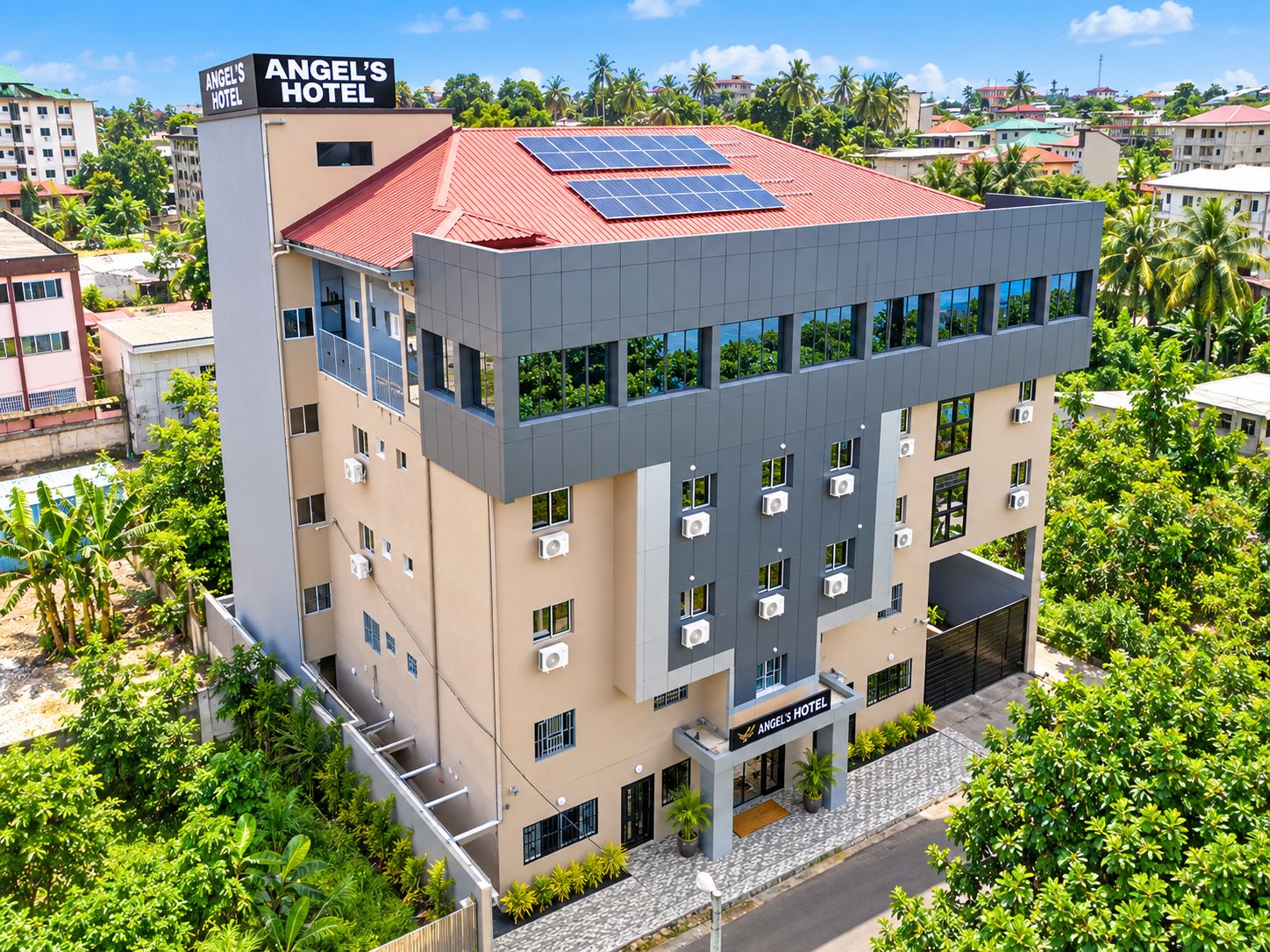 Um hotel com vários andares, teto plano, painéis solares e aparelhos de ar condicionado.