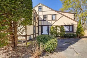 A two-story house with a symmetrical facade, a central entrance, and a small front yard with a tree and shrubbery. - 1 Mi to Beach: Spacious 5-bedroom house in terrific Sandwich with AC (Sandwich)