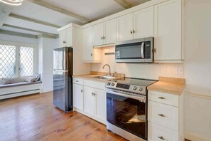 A kitchen with white cabinets, a stainless steel refrigerator, a microwave, a stove, and an oven. - 1 Mi to Beach: Spacious 5-bedroom house in terrific Sandwich with AC (Sandwich)