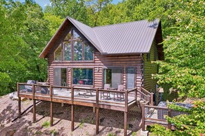 A log cabin with a deck, large windows, and a metal roof. - Starlight Retreat | Mt Views | Hot Tub | Fire Pit (Almond)