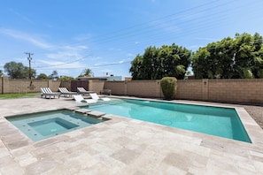 A rectangular swimming pool with a small hot tub, surrounded by a tiled deck with lounge chairs. - Scottsdale Montecito Retreat | Pool, Hot Tub, Putting Green & Games 🌵⛳ (Scottsdale)