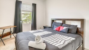 A neatly made bed with a grey duvet, pillows, and a rolled white towel. - Wfh-friendly Phoenix Home w/ Easy Freeway Access (Phoenix)