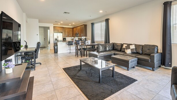 A modern living room with a sectional sofa, a coffee table, and a dining area with chairs. - Wfh-friendly Phoenix Home w/ Easy Freeway Access (Phoenix)