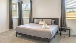 A bedroom with a bed, a nightstand, and a window with blinds. - Wfh-friendly Phoenix Home w/ Easy Freeway Access (Phoenix)