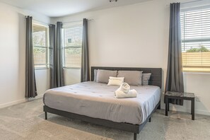 Ein Schlafzimmer mit einem Bett, einem Nachttisch und einem Fenster mit Jalousien.