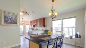 A modern kitchen with a dining area, featuring a large island, dark countertops, and a chandelier. - Extended Stays Welcome! Waterfront Gem in Orlando (Orlando)