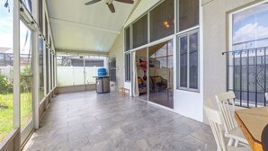 A covered patio area with a ceiling fan, large windows, and a tiled floor. - Extended Stays Welcome! Waterfront Gem in Orlando (Orlando)