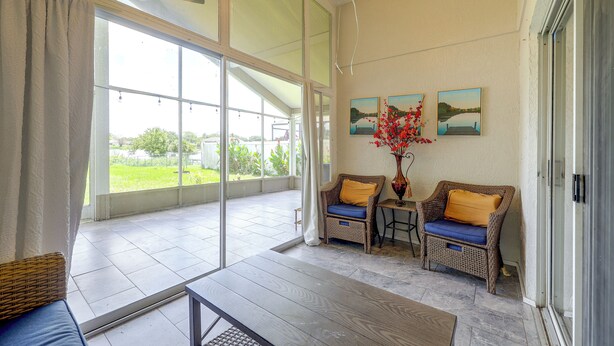 A spacious room with large windows, wicker furniture, and artwork on the walls. - Extended Stays Welcome! Waterfront Gem in Orlando (Orlando)