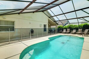 An indoor swimming pool with a glass ceiling, surrounded by lounge chairs and a table. - Heated Pool & Game Room! Family Hub 9 Mi to Disney (Davenport)