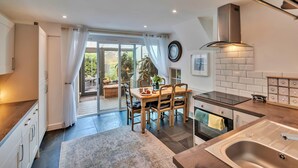 Una cocina moderna con comedor, ventanas amplias y vistas al exterior.