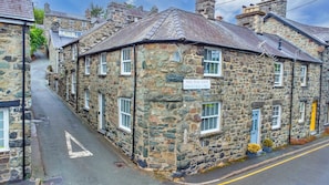 A stone building with a sign reading 'HEOL PLAS UCHAF SPRINGFIELD STREET.' - Chester House (Dolgellau)
