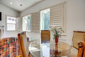 A room with a glass-top table, chairs with striped upholstery, and a vase with flowers. - Full Kitchen! King Suite Near Snowbasin (Layton)