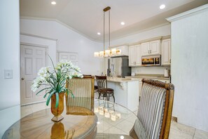 A modern kitchen with white cabinetry, stainless steel appliances, and a glass dining table with chairs. - Full Kitchen! King Suite Near Snowbasin (Layton)