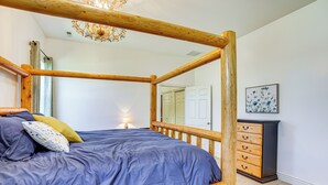 A bedroom with a four-poster bed, a dresser, a lamp, and a painting on the wall. - Full Kitchen! King Suite Near Snowbasin (Layton)