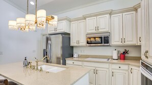 A kitchen with white cabinetry, stainless steel appliances, a granite countertop, and a chandelier. - Full Kitchen! King Suite Near Snowbasin (Layton)