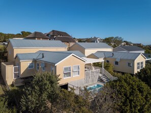 A residential area with multiple houses featuring gabled roofs and a swimming pool. - Afternoon Delight NT3 (Knysna)