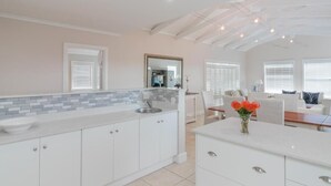 Una cocina moderna con una isla grande, armarios blancos y un salpicadero de azulejos.