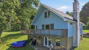 A two-story house with a balcony, a chimney, and a stack of firewood. - Lakefront Paradise on Lake Wallenpaupack w/ Dock (Hawley)