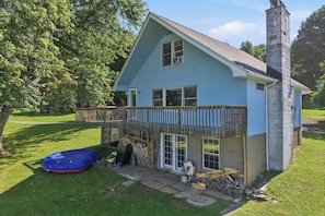A two-story house with a balcony, a chimney, and a stack of firewood. - Lakefront Paradise on Lake Wallenpaupack w/ Dock (Hawley)