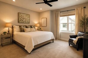 A bedroom with a bed, nightstands, a desk, a chair, a ceiling fan, and a window with curtains. - Magnolia Manor at College Station & Texas A&M (College Station)