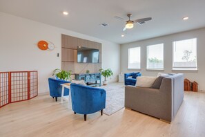 A modern living room with a sofa, chairs, a TV, and a ceiling fan. - Fenced Yard! Family Getaway, Near Texas Ski Ranch (San Marcos)