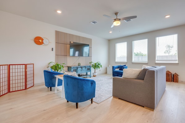 A modern living room with a sofa, chairs, a TV, and a ceiling fan. - Fenced Yard! Family Getaway, Near Texas Ski Ranch (San Marcos)