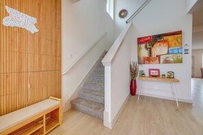 Un escalier avec un mur en bois et une pancarte de bienvenue, un tableau et un petit bureau agrémenté de plantes.