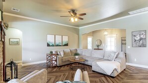 A spacious living room with a sectional sofa, a coffee table, and a fireplace. - Gateway to Downtown Okc! Elegant Home (Yukon)