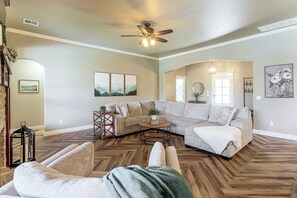A spacious living room with a sectional sofa, a coffee table, and a fireplace.