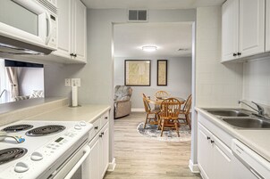 Una cocina moderna con armarios blancos, estufa integrada y un fregadero.