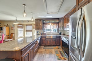 A spacious kitchen with a large island, stainless steel appliances, and wooden cabinetry. - Swim, Grill & Relax! Copperas Cove Family Home (Copperas Cove)