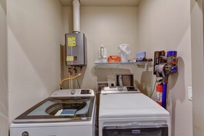 A laundry area with a washing machine, dryer, and a water heater.