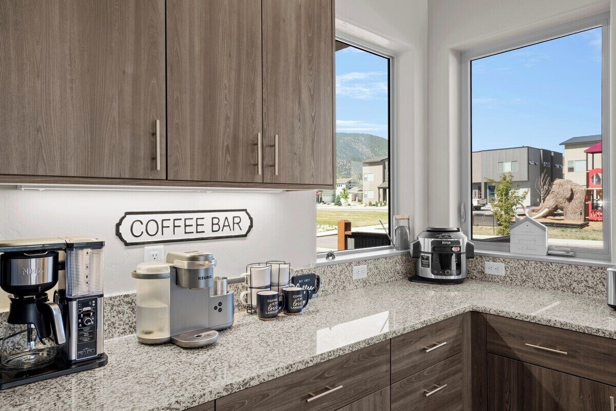 Una cocina con barra de café, máquinas de café y vista al exterior.