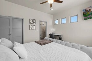 Ein Schlafzimmer mit Bett, Schreibtisch und Dusche.