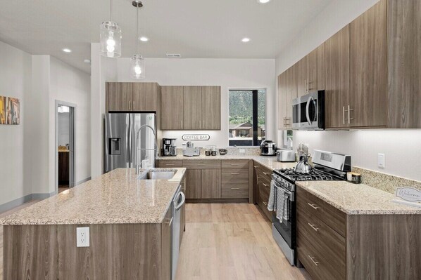 A modern kitchen with granite countertops, stainless steel appliances, and wooden cabinetry. - 3 King Beds 3 Baths 2-car Garage (Poncha Springs)