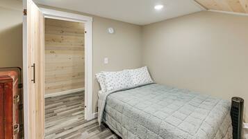 A bedroom with a bed, a door leading to a wooden closet, and a radiator.