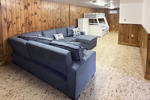 A room with a blue sofa set, a white dresser, and a bunk bed. - Fall Fun in the Berkshires: Yard, Patio, Playset (Pittsfield)