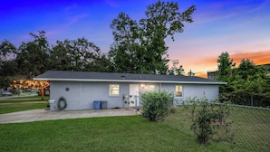 A single-story house with a front yard, a visible garage door, and a small porch area. - 2 Nature Coast Units w/ Shared Courtyard (Homosassa)