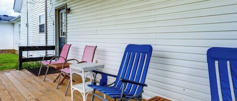 A porch with outdoor furniture including a table and chairs.