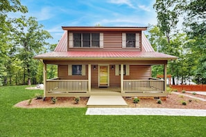 A two-story wooden house with a front porch, a red roof, and a well-maintained lawn. - Dock & Fire Pit! Lake Gaston Cabin in Macon (Macon)