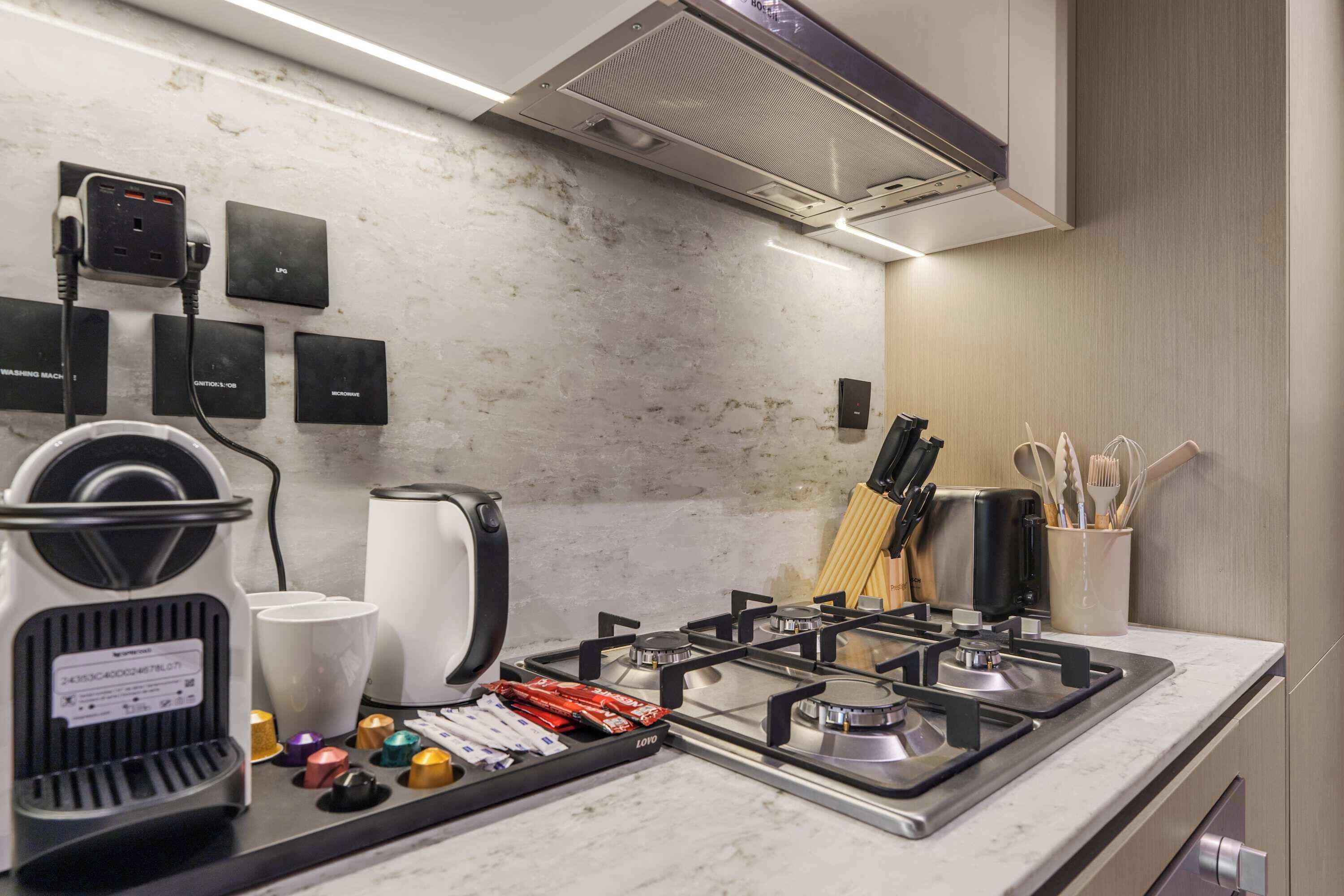 A modern kitchen with a gas stove, coffee maker, and various appliances.