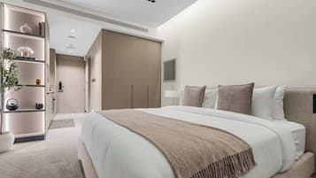 Una moderna camera d'hotel con un letto grande, un armadio, un comodino e una televisione.