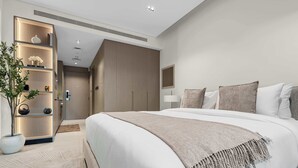 A modern hotel room with a large bed, a bedside table, a lamp, and a plant. - Arjan Studio with Pool View, Jogging Track & BBQ (Arjan)