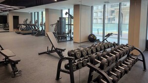 A gym with exercise equipment, including treadmills, a bench press, and a rack of dumbbells. - Arjan Studio with Pool View, Jogging Track & BBQ (Arjan)