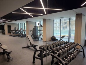 A gym with exercise equipment, including treadmills, a bench press, and a rack of dumbbells. - Arjan Studio with Pool View, Jogging Track & BBQ (Arjan)