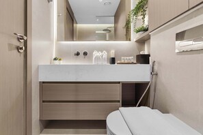 A modern bathroom with a white vanity, a toilet, and a shower area. - Arjan Studio with Pool View, Jogging Track & BBQ (Arjan)