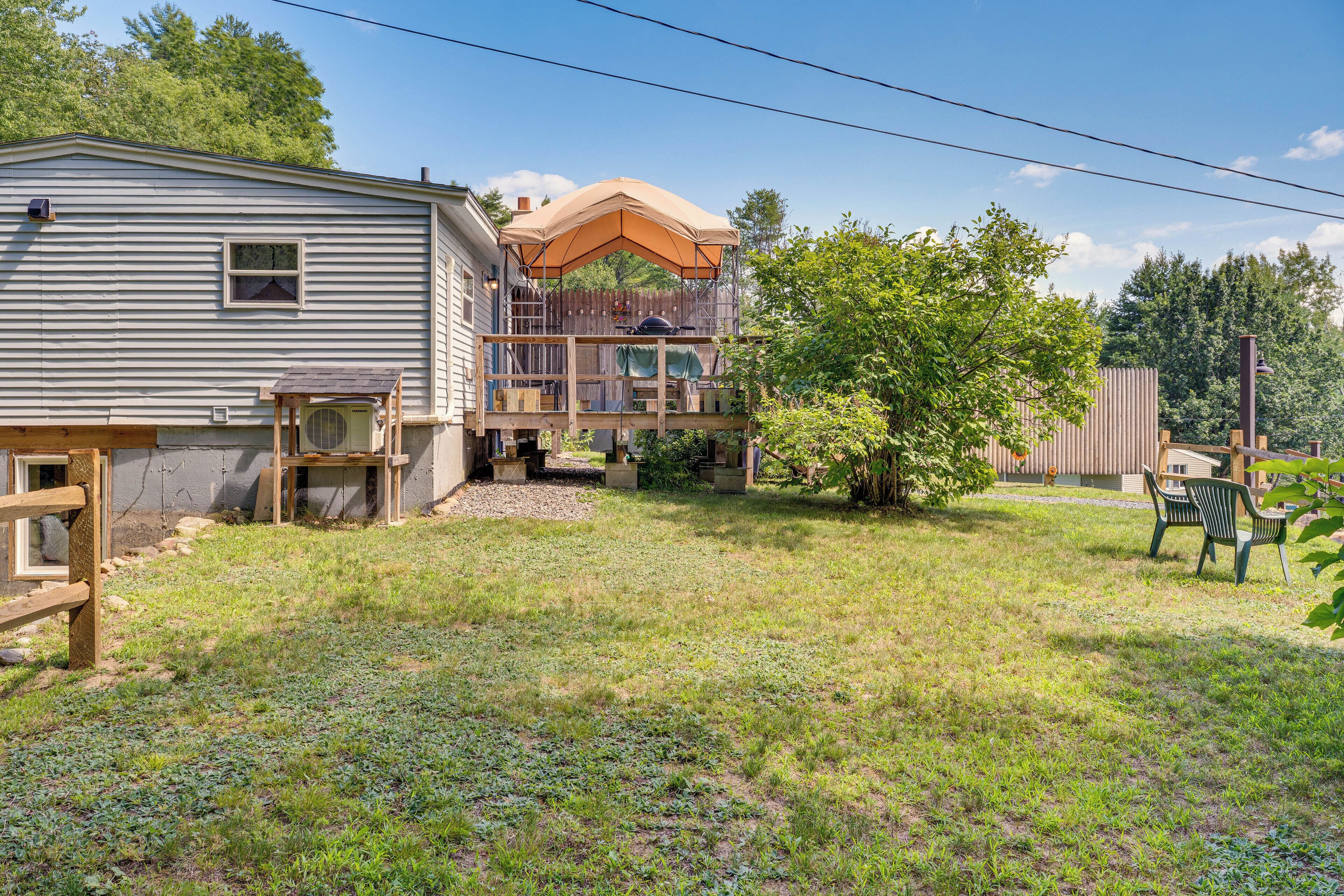 A two-story house with a deck, a small outdoor grill, and a covered patio area.