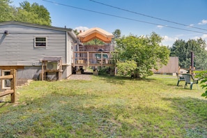 A two-story house with a deck, a small outdoor grill, and a covered patio area.